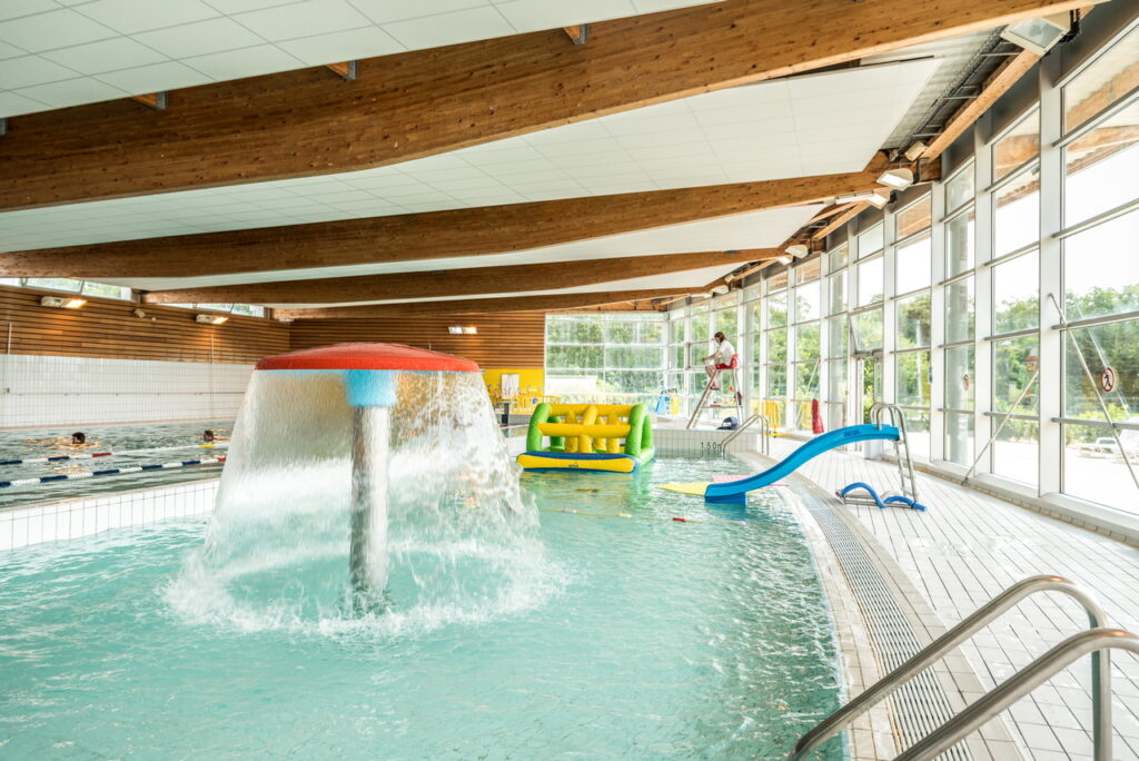 Espace intérieur de la piscine avec des jeux d'eau et un toboggan